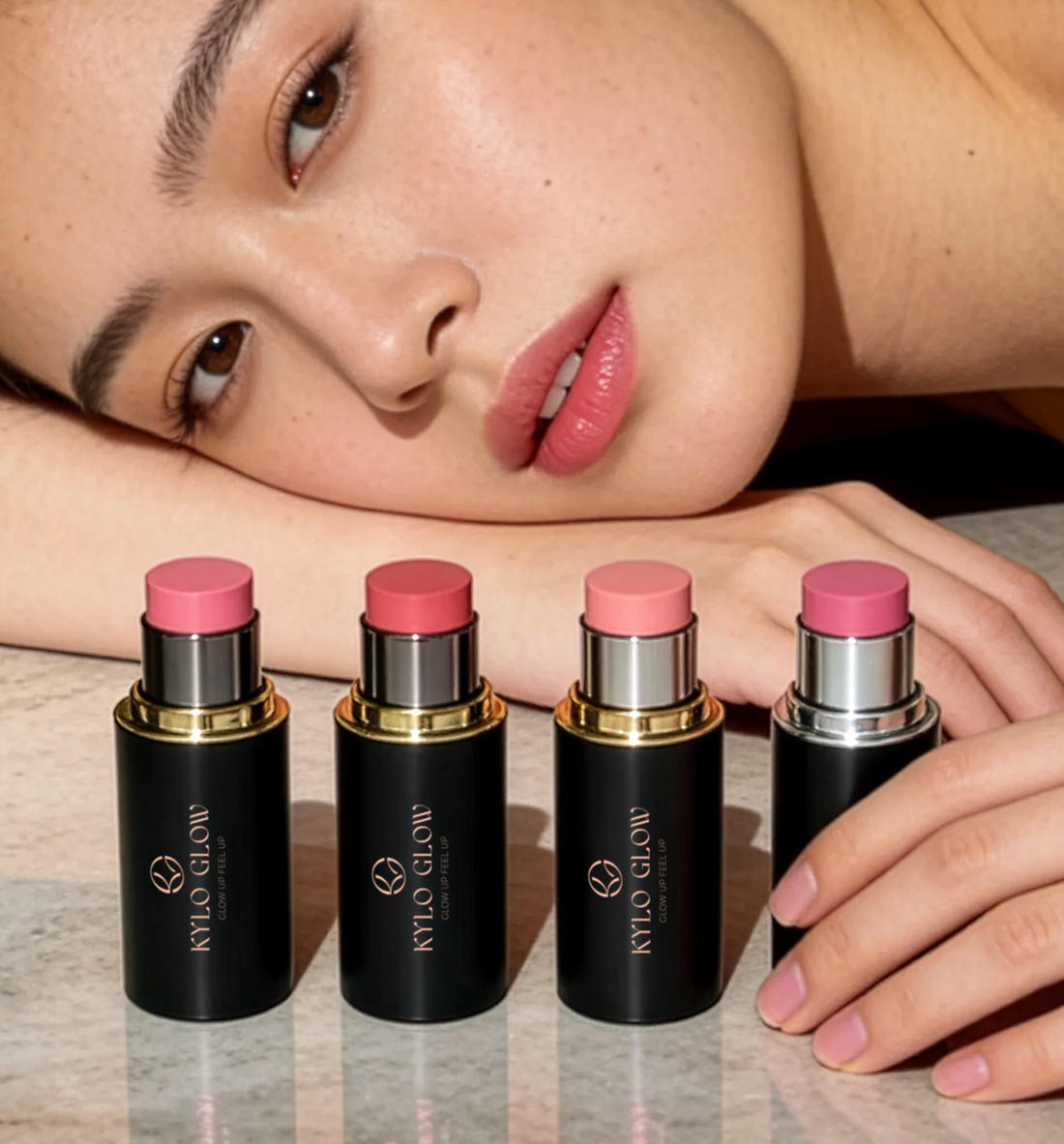 A close portrait resting beside a row of KYLO GLOW blush sticks